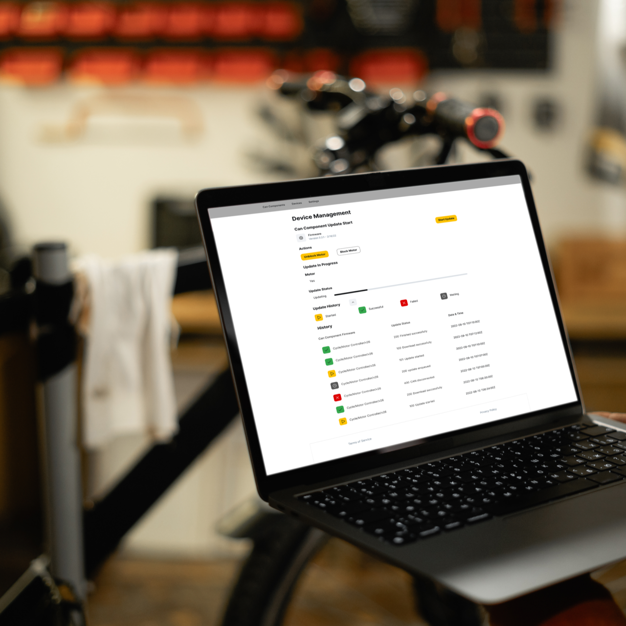 Offener Laptop, mit Device, im Hintergrund ein Fahrrad.